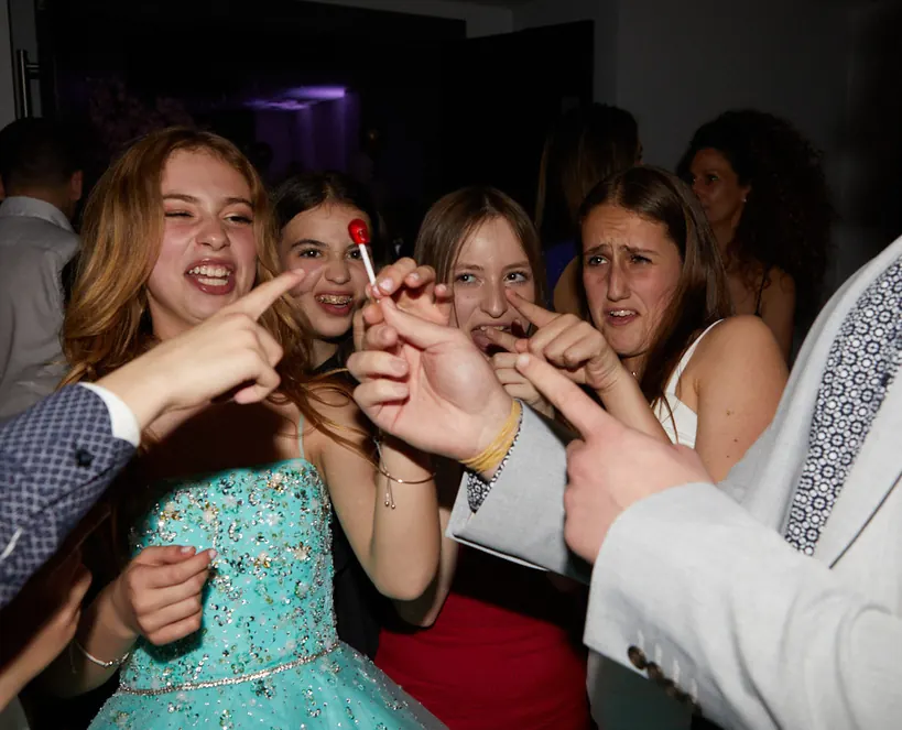 Teenage guests amazed by close up magic at a simcha