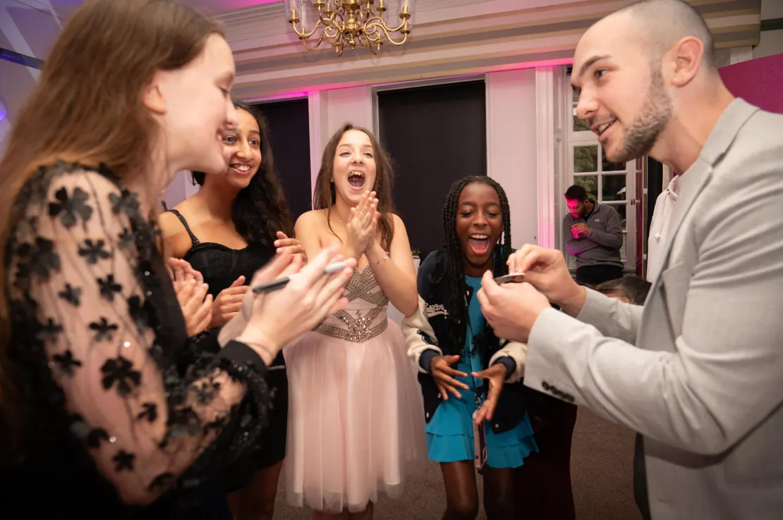 Guests laughing at Daniel Bower’s magic at a Bat Mitzvah
