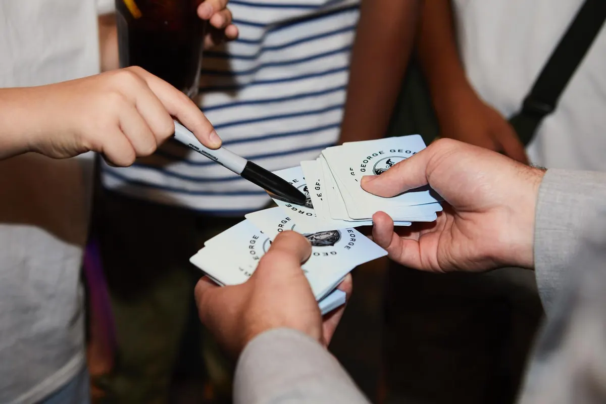Custom playing cards being signed during a trick