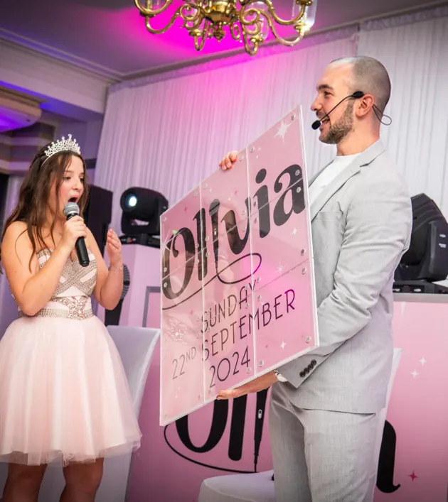 Daniel Bower revealing a personalised sign on stage