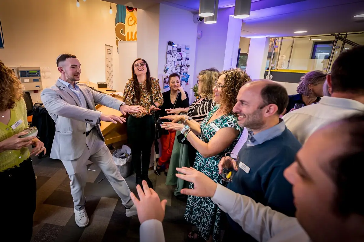 Magician engaging guest on interactive magic smiling and laughing during special event.