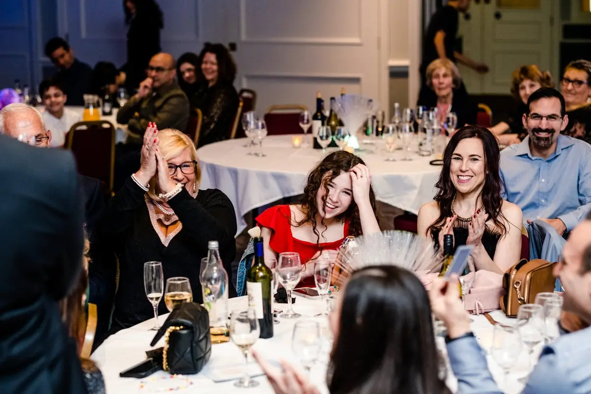 Guests at a seated dinner reacting to Daniel Bower’s magic