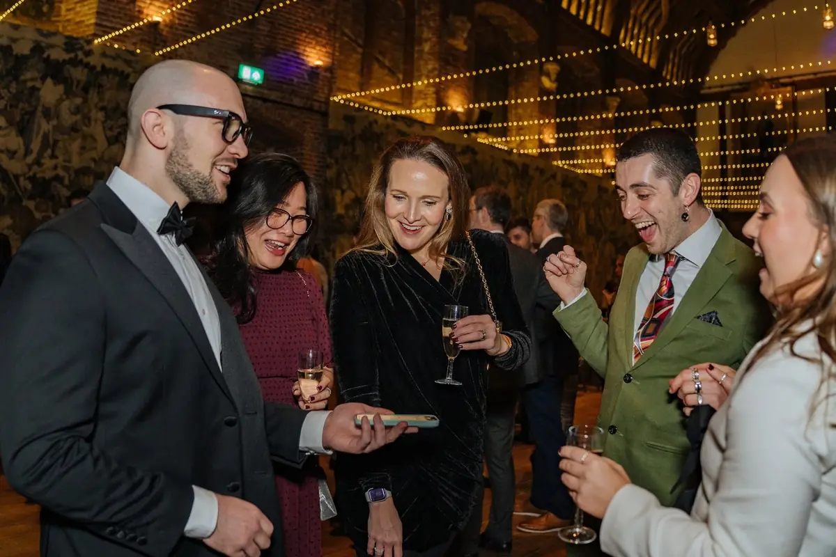 Guests amazed by close-up sleight-of-hand tricks during corporate christmas event.
