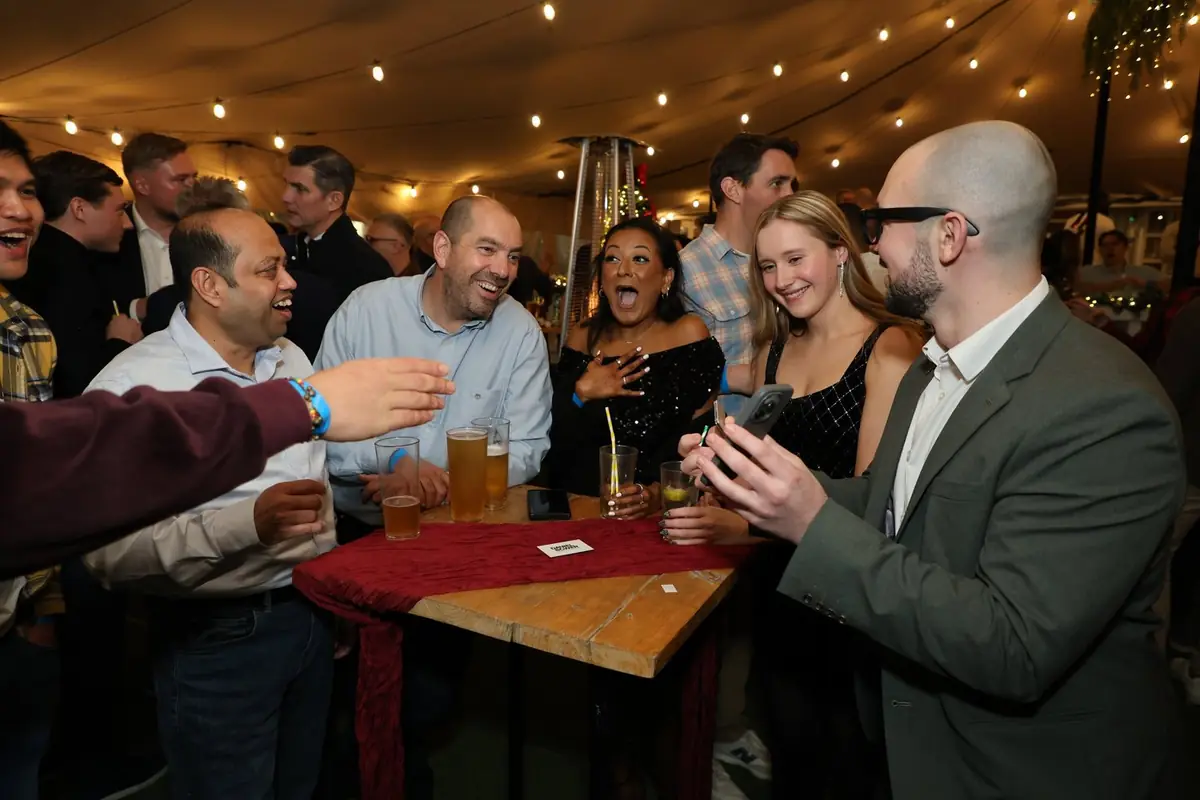 Close-up magician delighting employees during company holiday party.