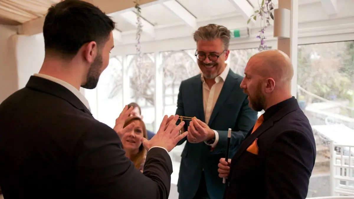 Daniel Bower performing magic for guests at a party