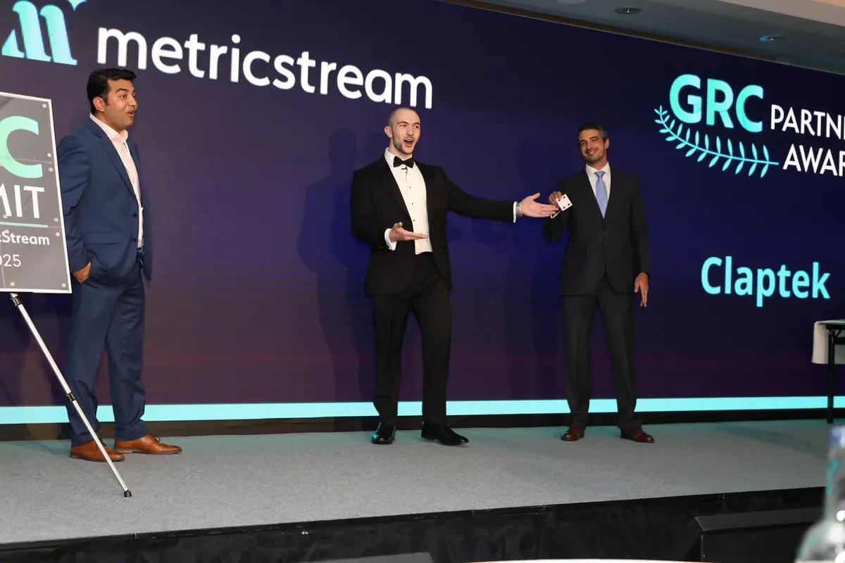 Professional magician performing grand illusions on stage at company awards night.