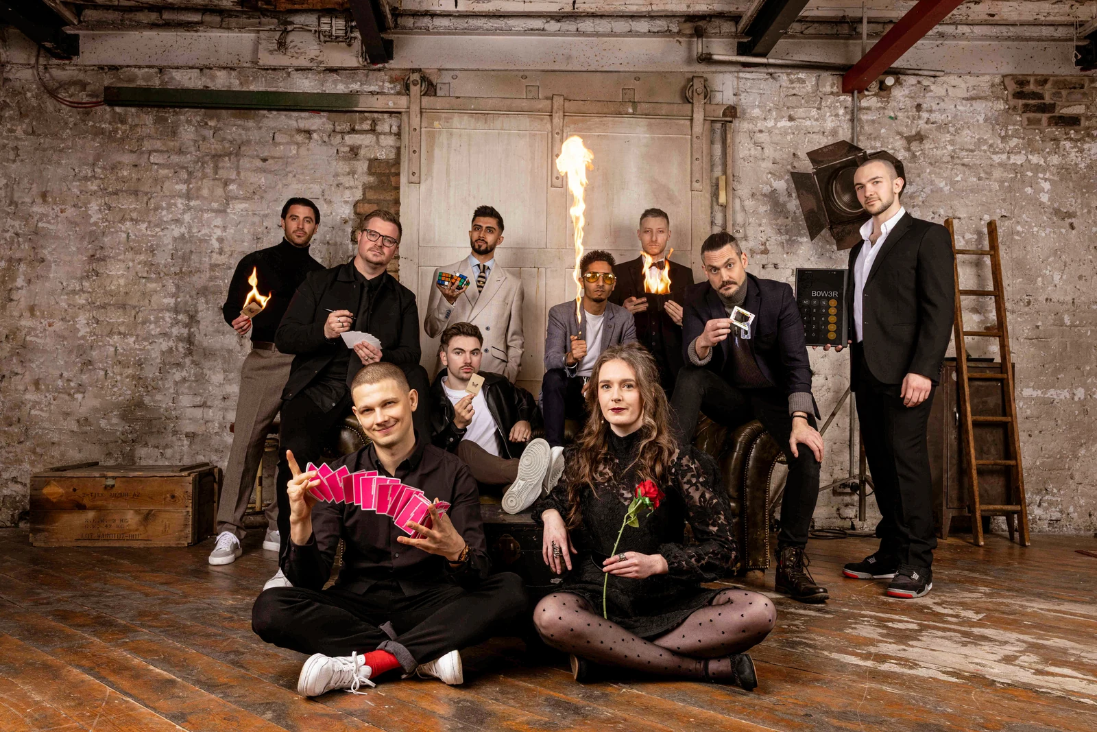 A group of magicians together, with playing cards, a Rubik’s cube and other magic props.